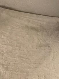 Filthy bedspread and sunken in mattress