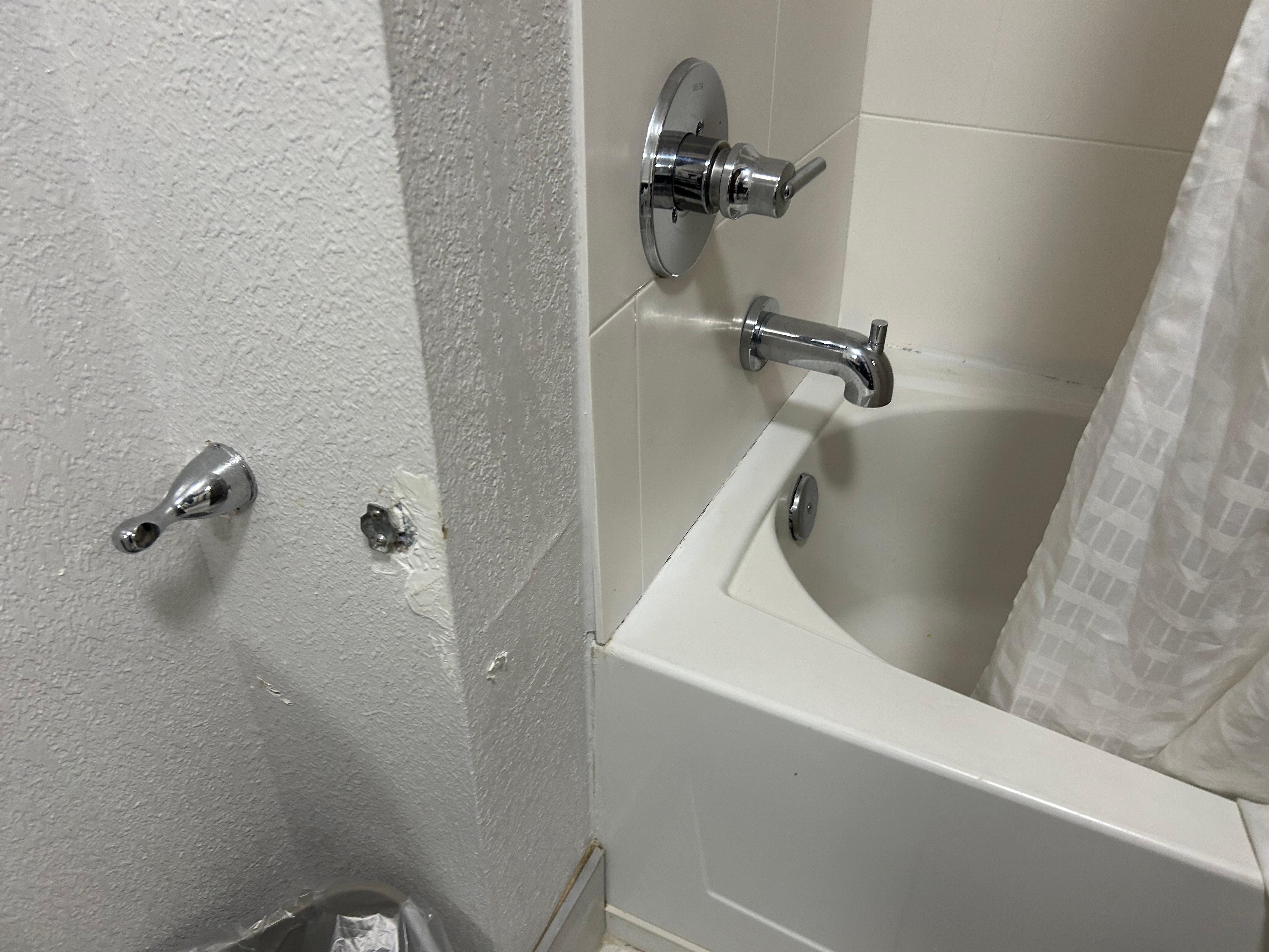 Broken toilet paper dispenser and mildewed shower