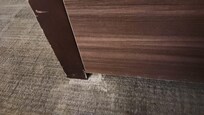Base of dresser and carpet in room