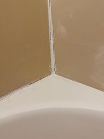Caulking job was done poorly showing there is no complete water barrier around the tub.