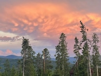 Cotton candy clouds drifted over Grand Lake, painting the sky in hues of peach and lavender—one of many breathtaking views from Whistling Moose Lodge.