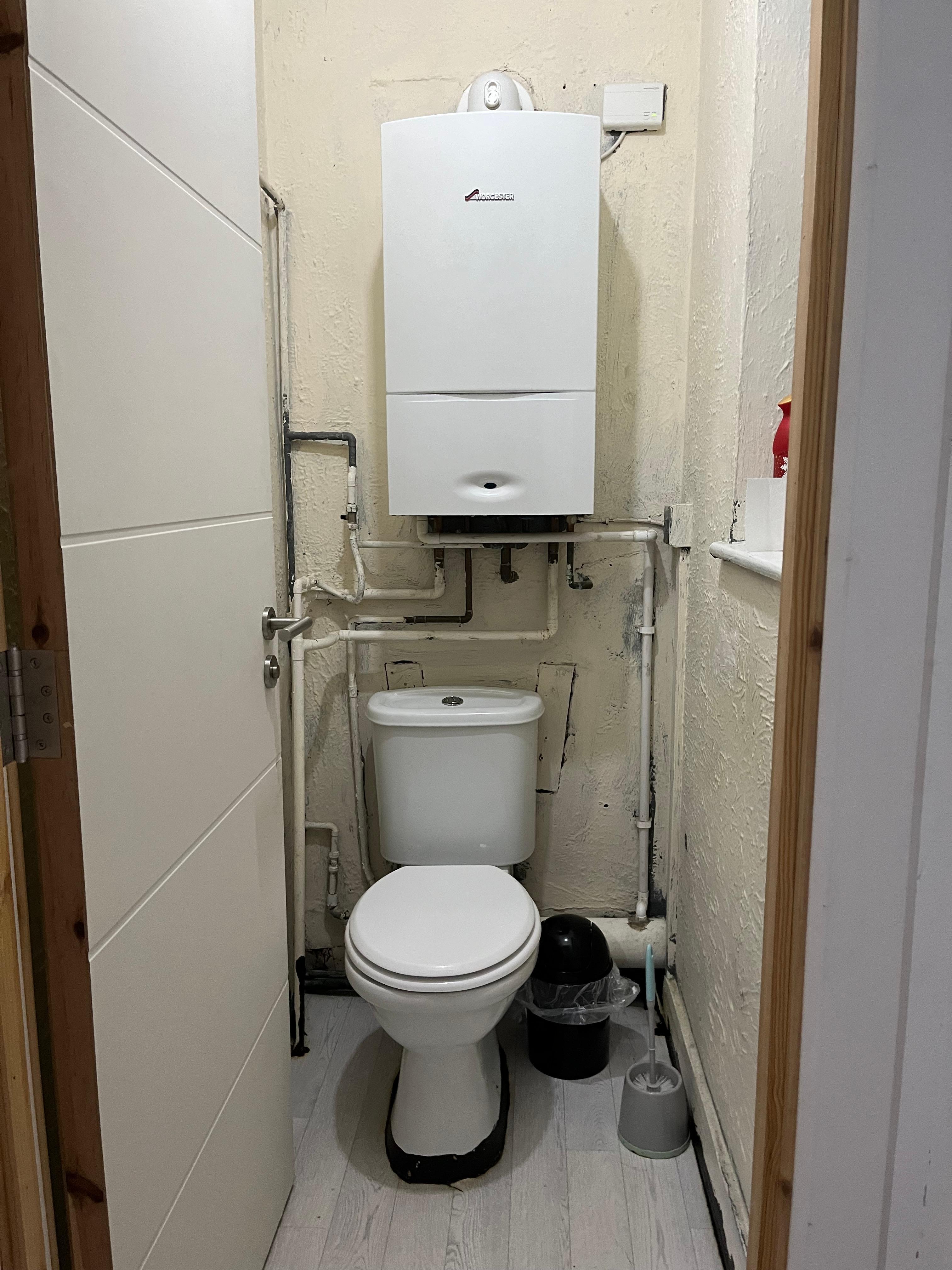 Dangerous toilet with live combi boiler on top of it 