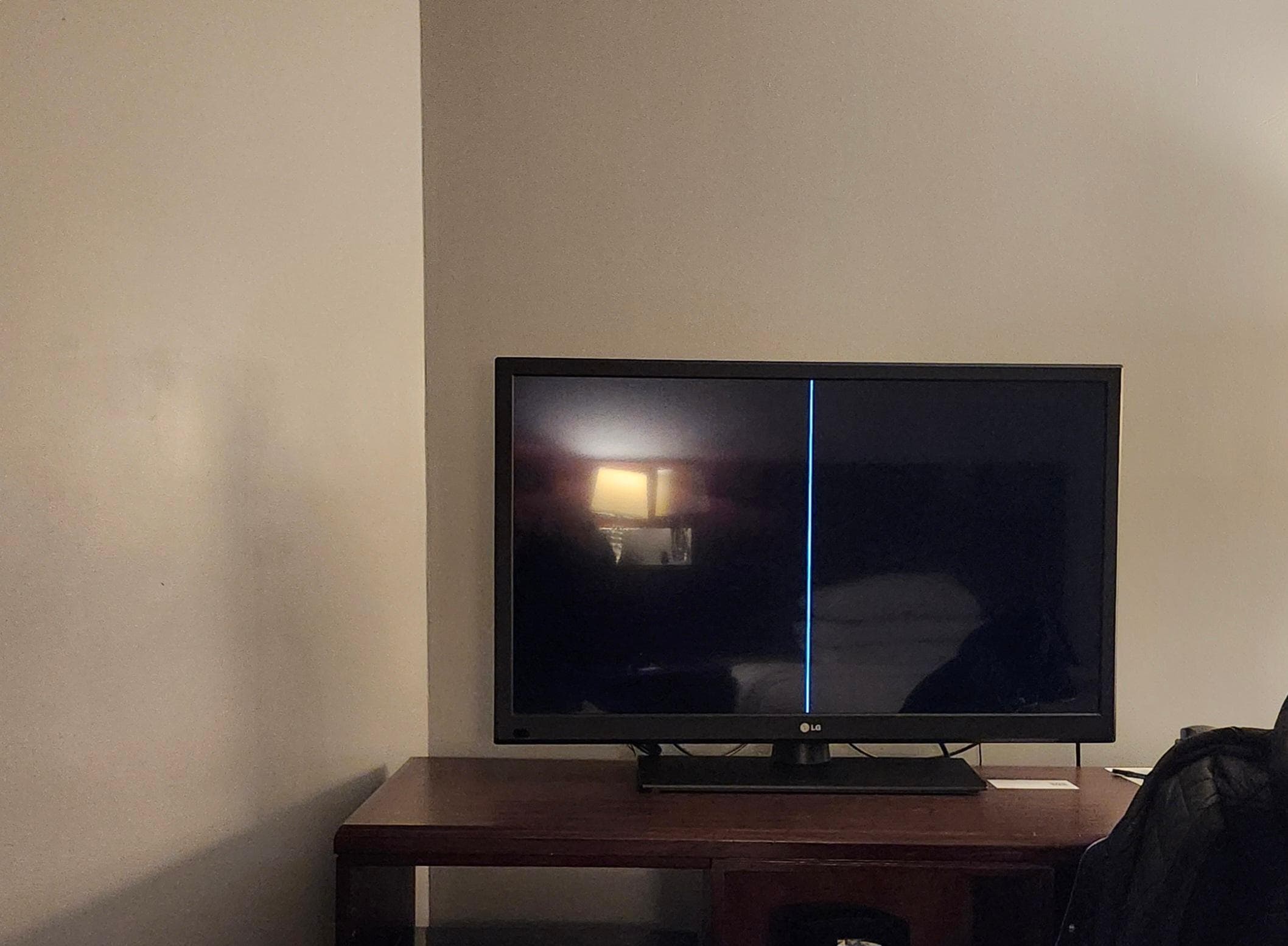 Broken TV with a giant line down the center of the screen.