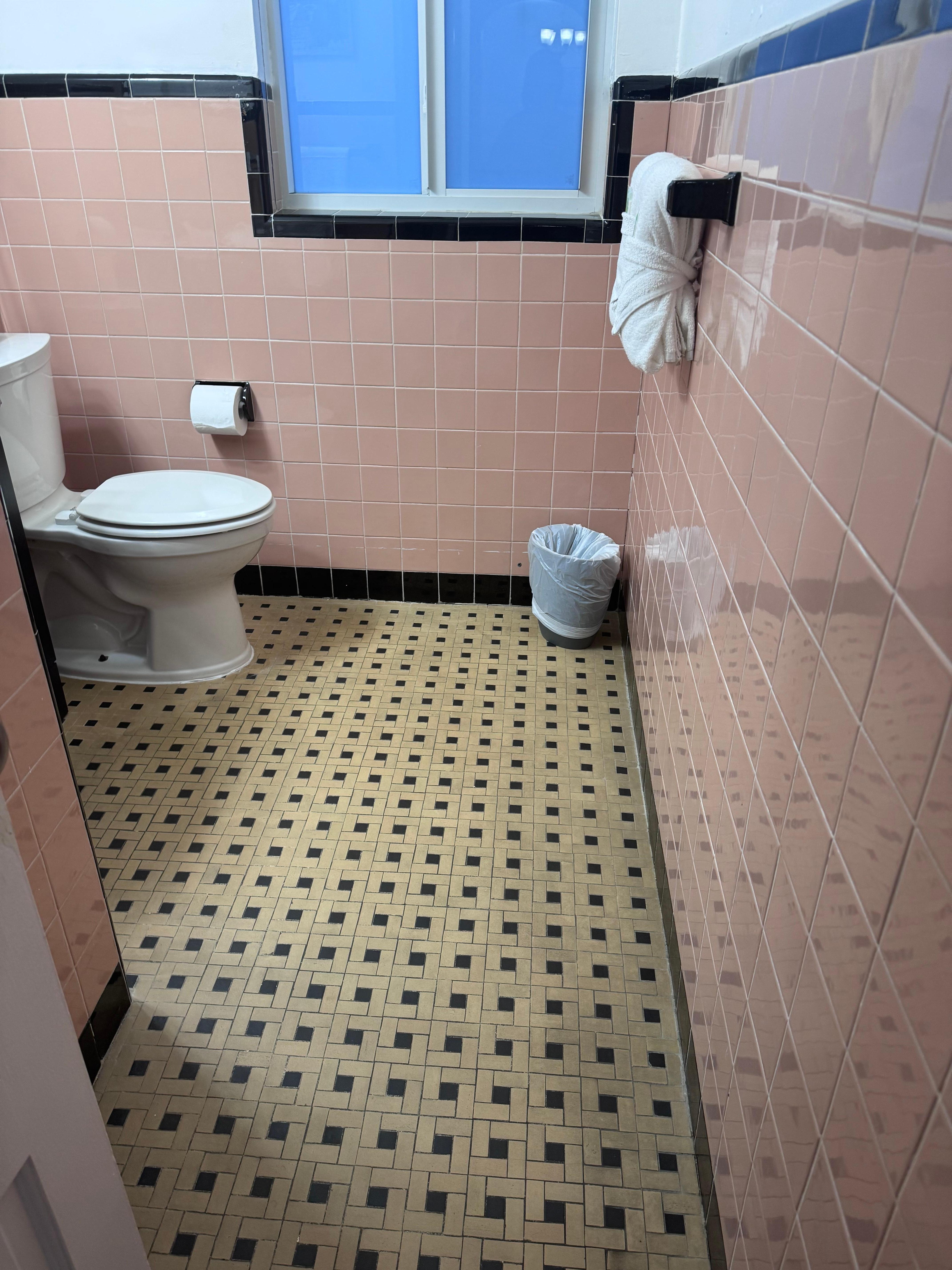 Outdated bathroom with broken tile and leaky shower head 