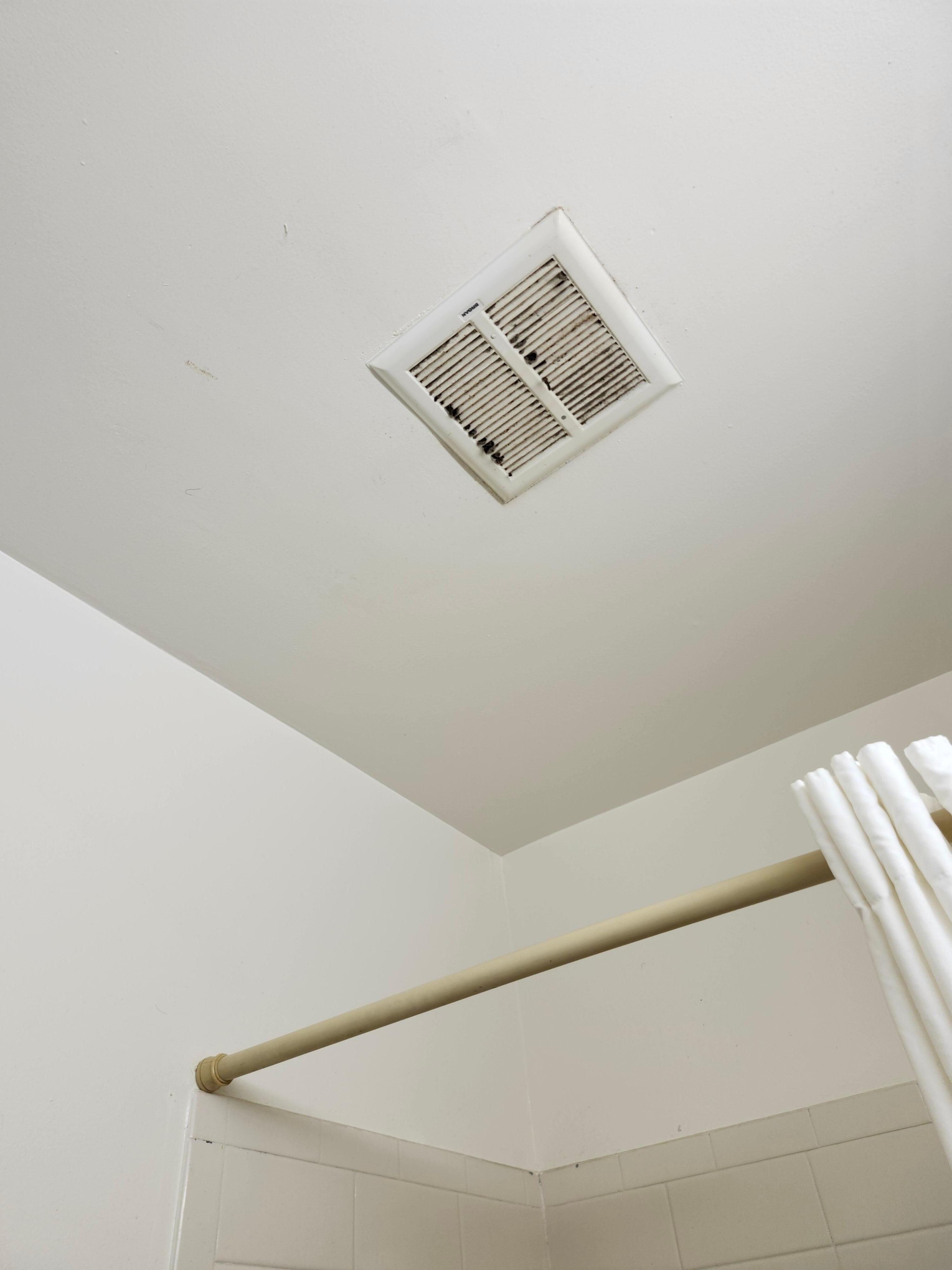 Bathroom vent has black stuff coming out of it.