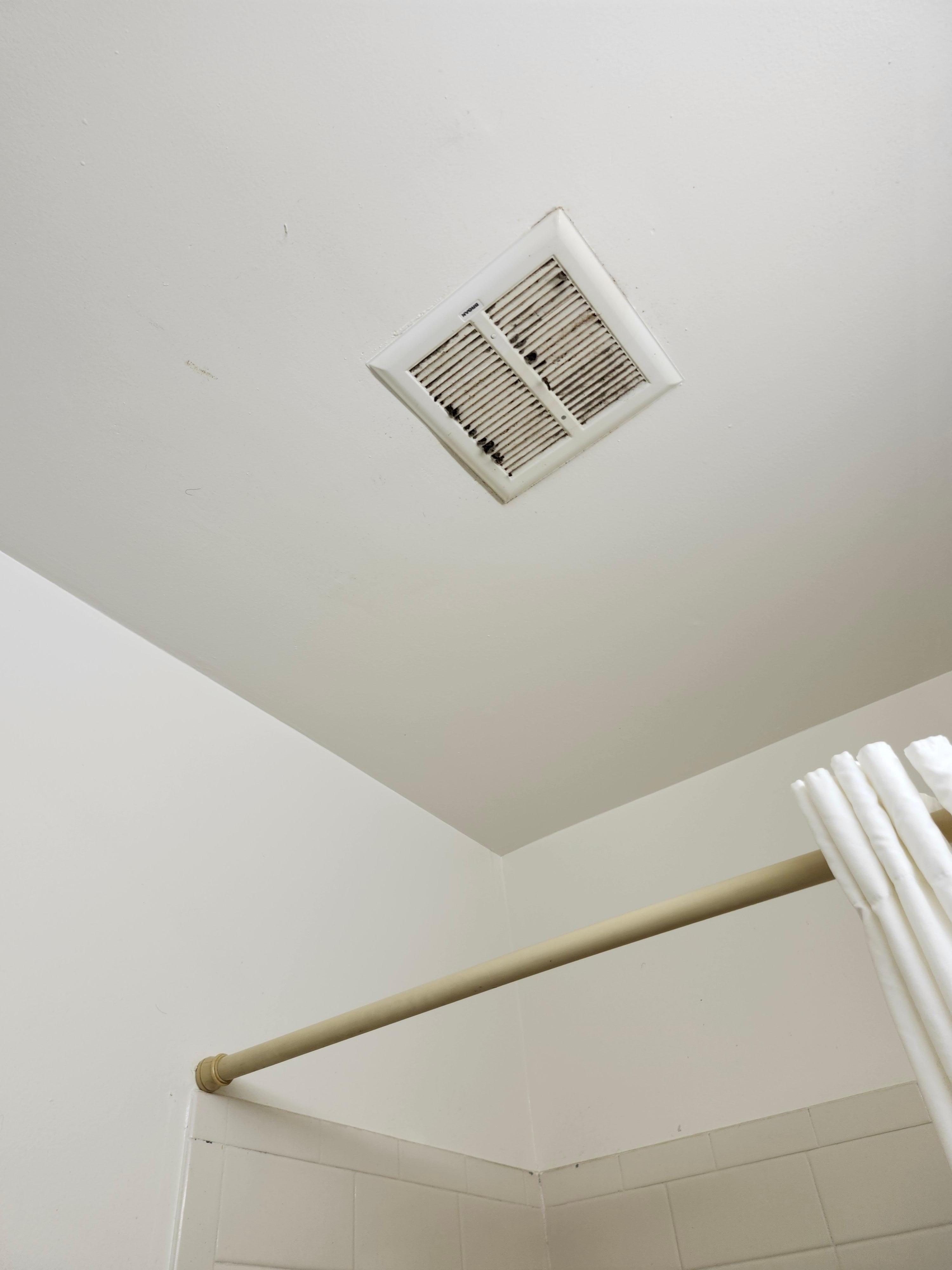 Bathroom vent has black stuff coming out of it.