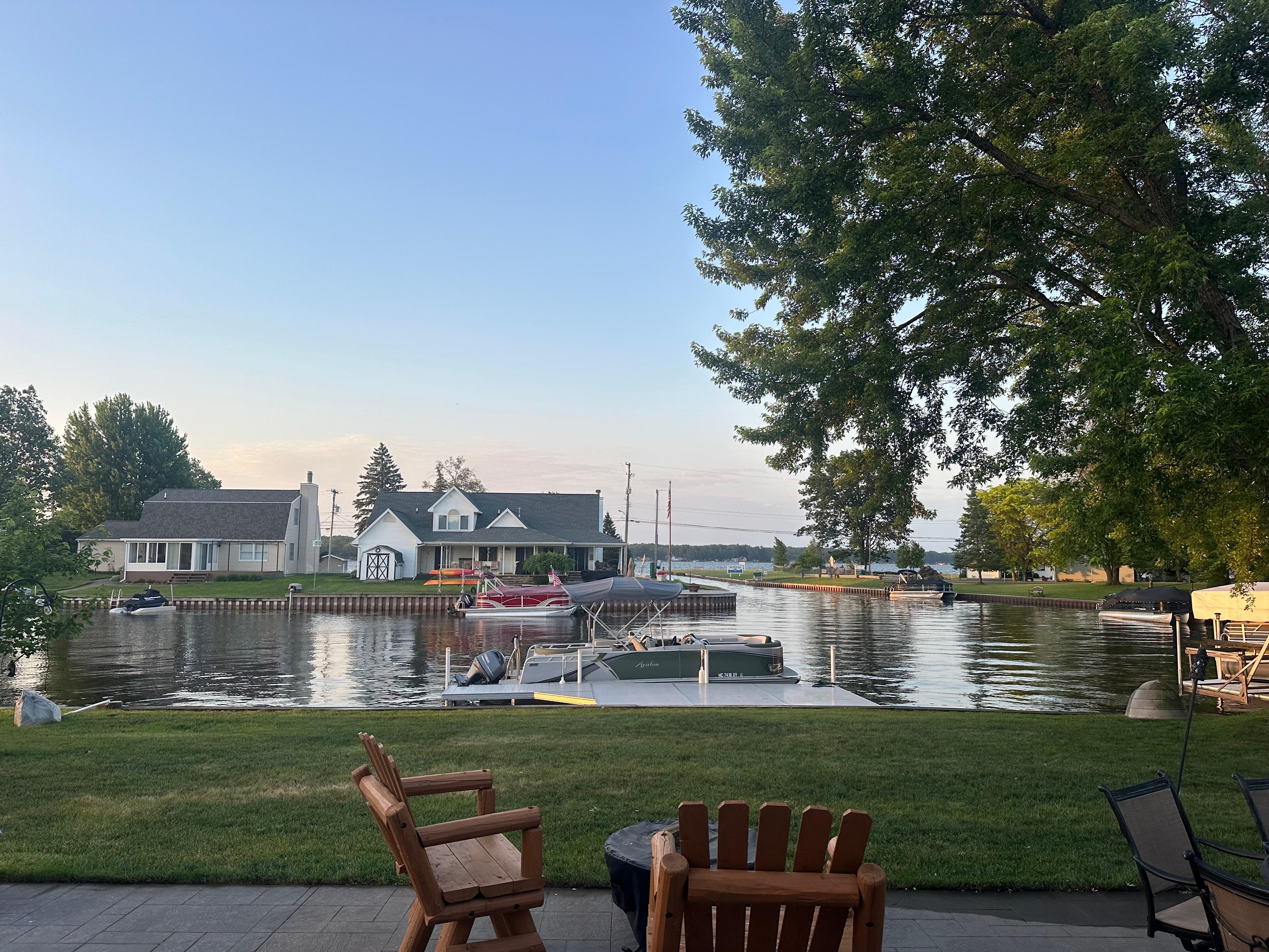 Our boat at the dock; view from backdoor of cottage! You can see the canal & lake ahead!