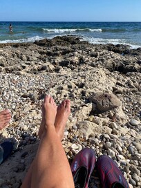 Strand med klipper foran hotellet.