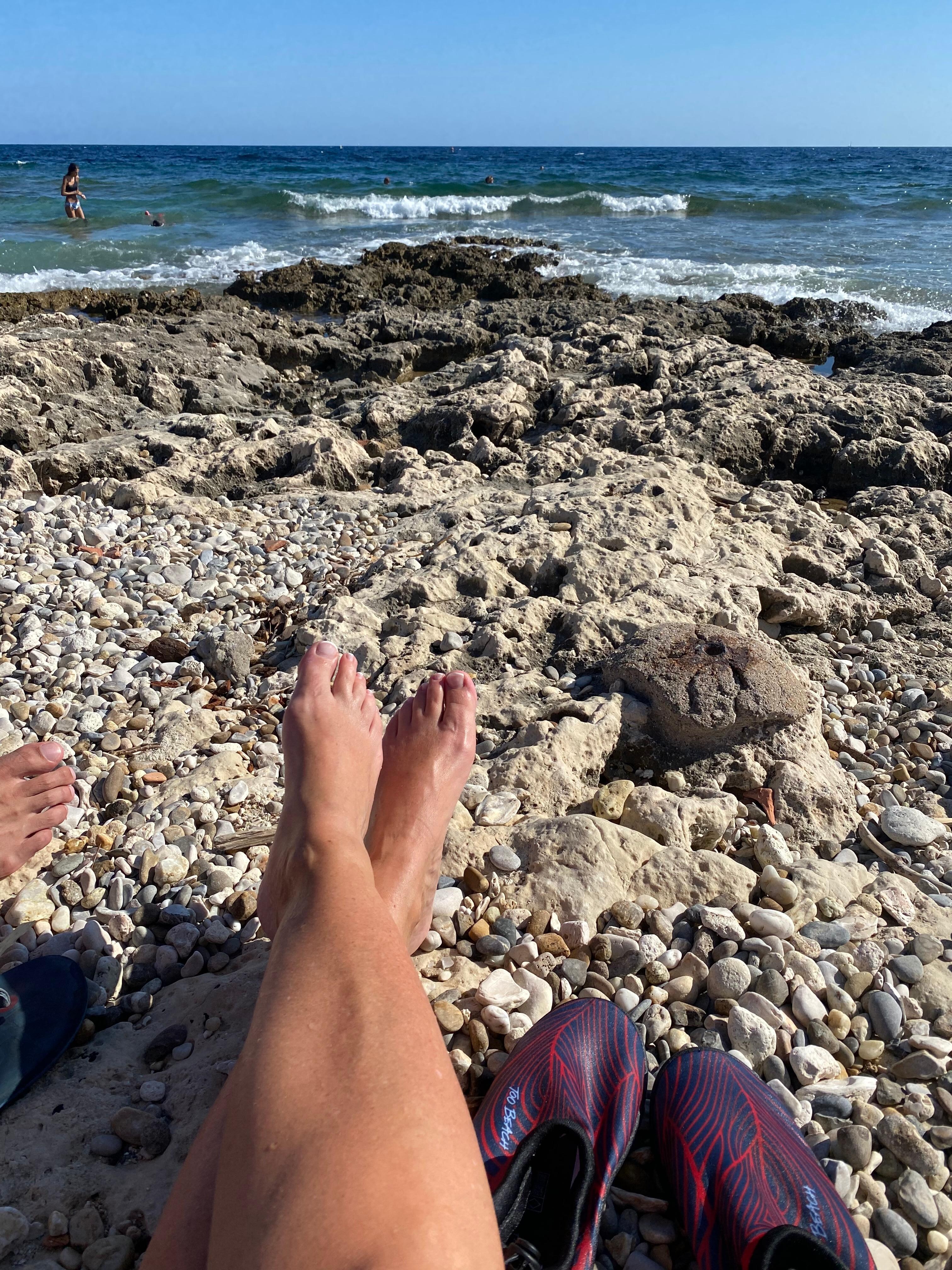 Strand med klipper foran hotellet.
