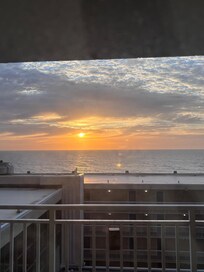 Ocean sunrise from balcony door.