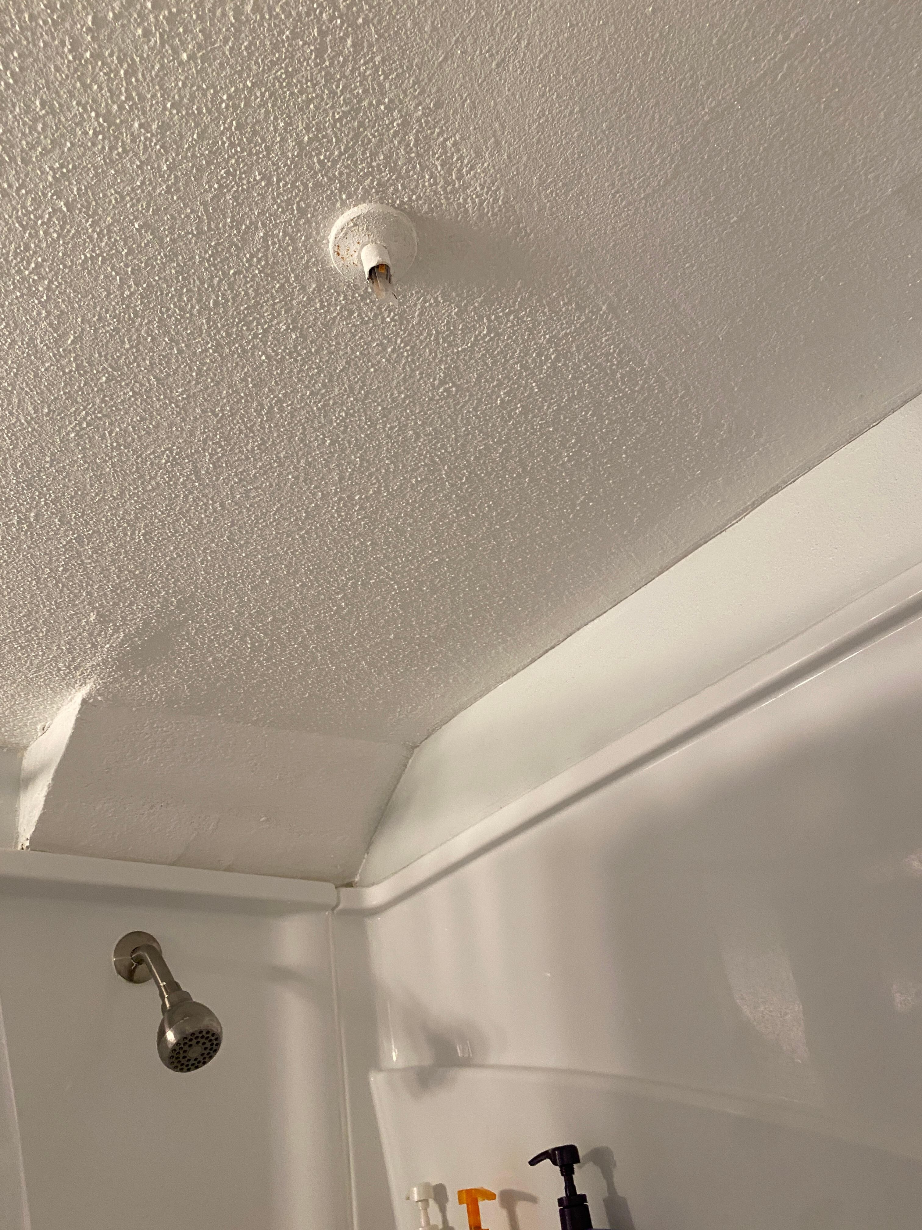 Exposed old plumbing pipe. Shower knob loose, coming out of the wall and difficult to turn on and off.