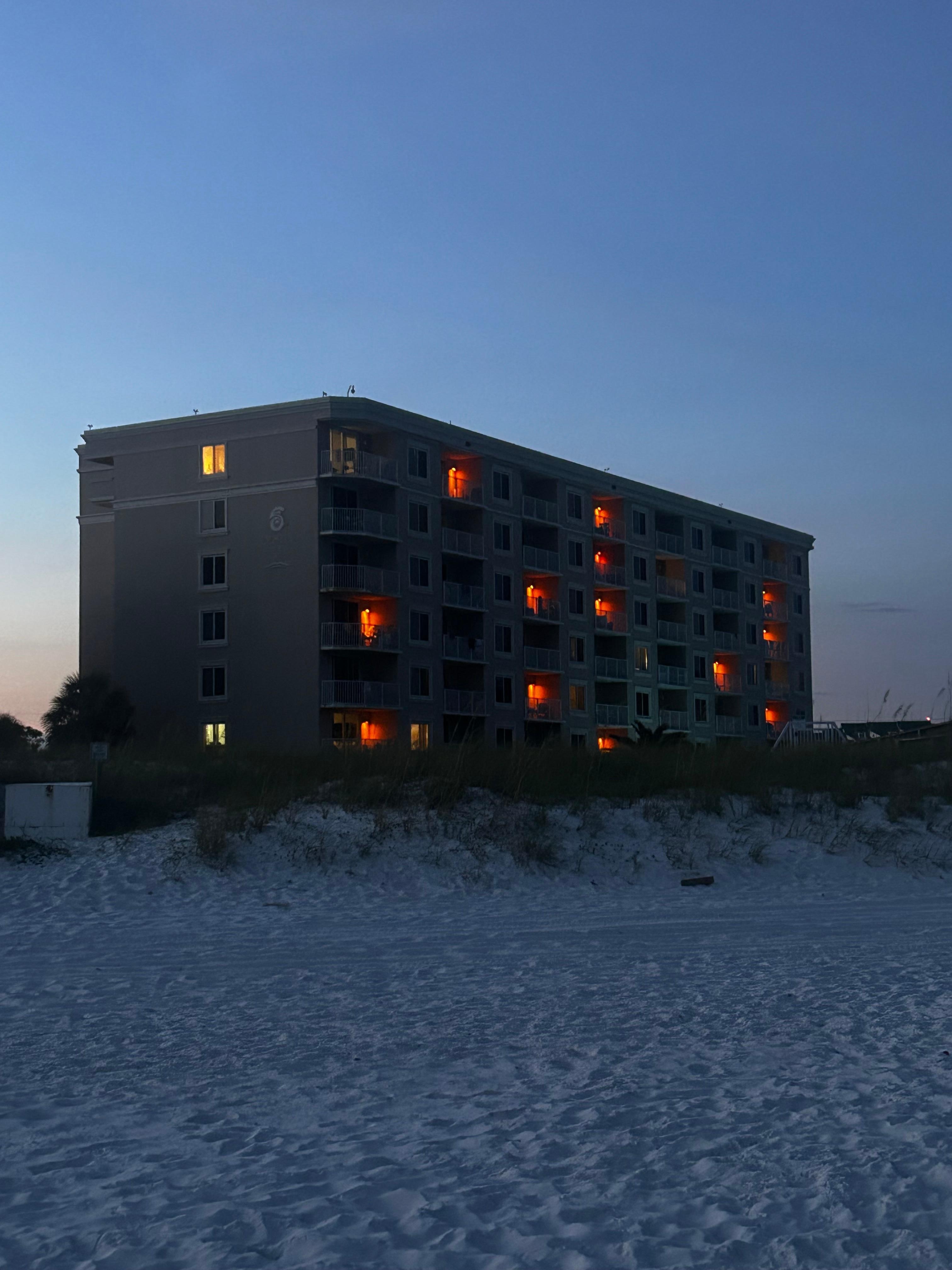 View of condo at night from beach 