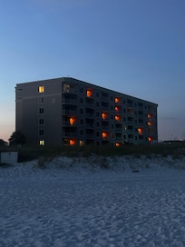 View of condo at night from beach