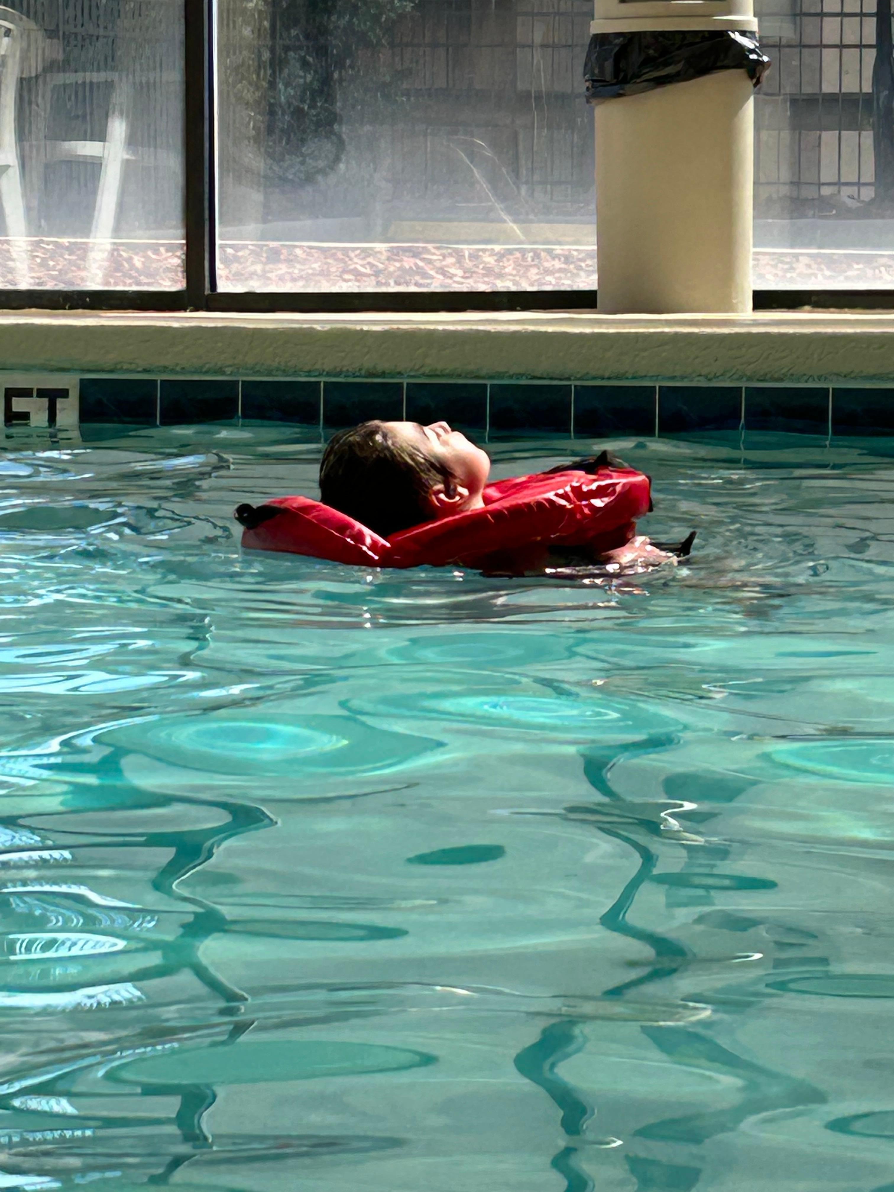 Maddie lounging in the pool.