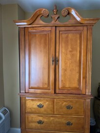 Cabinet offset to the right with a tv inside. Not sure why this wouldn’t be directly across from the bed instead of in the corner?