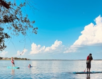 A perfect day on the water — gliding across a glassy lake under a sky full of dreams and clouds.