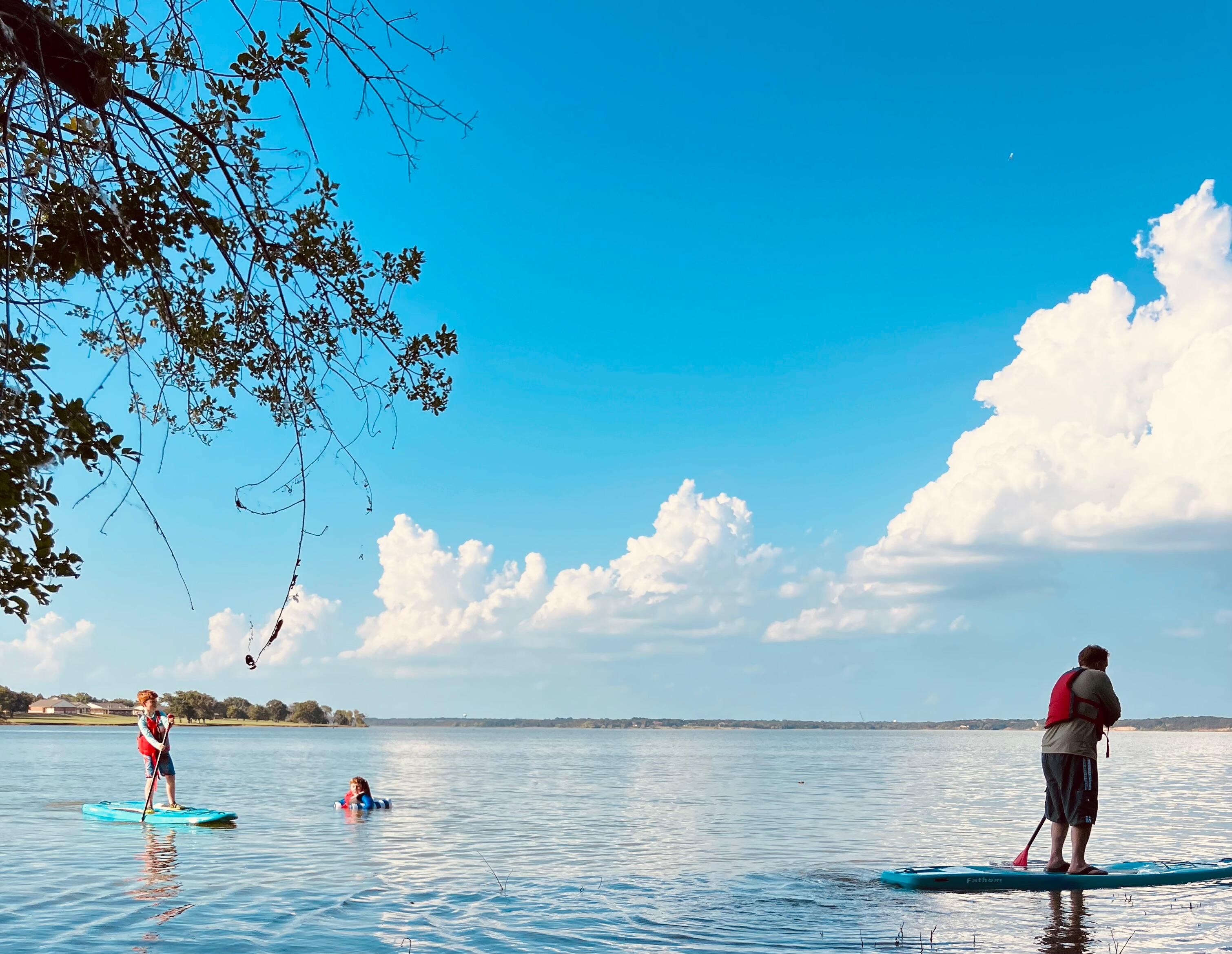 A perfect day on the water — gliding across a glassy lake under a sky full of dreams and clouds.