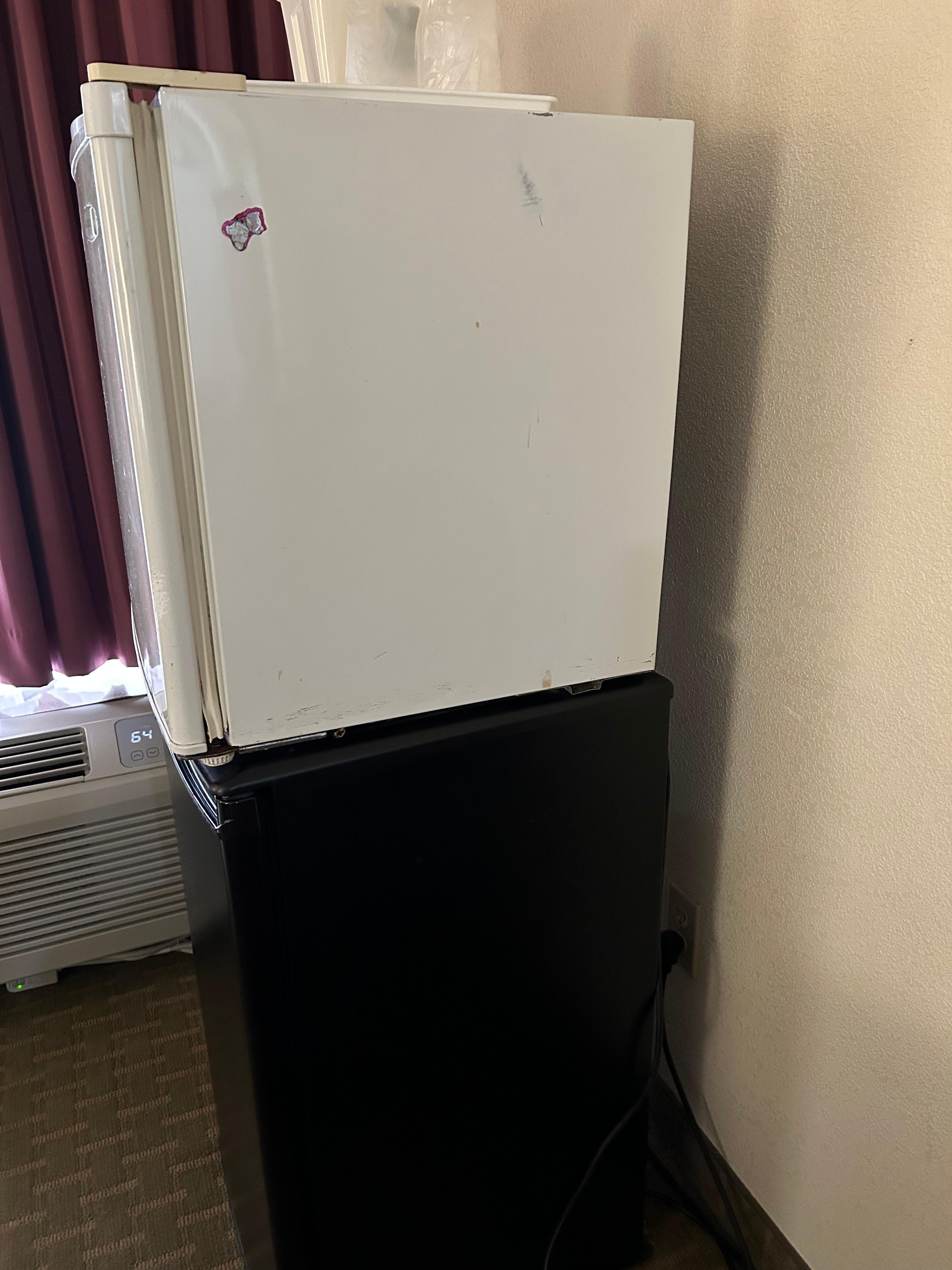 2 mini fridges stacked up on each other 1 not plugged up