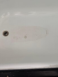 Dirty bathtub with some cotton balls