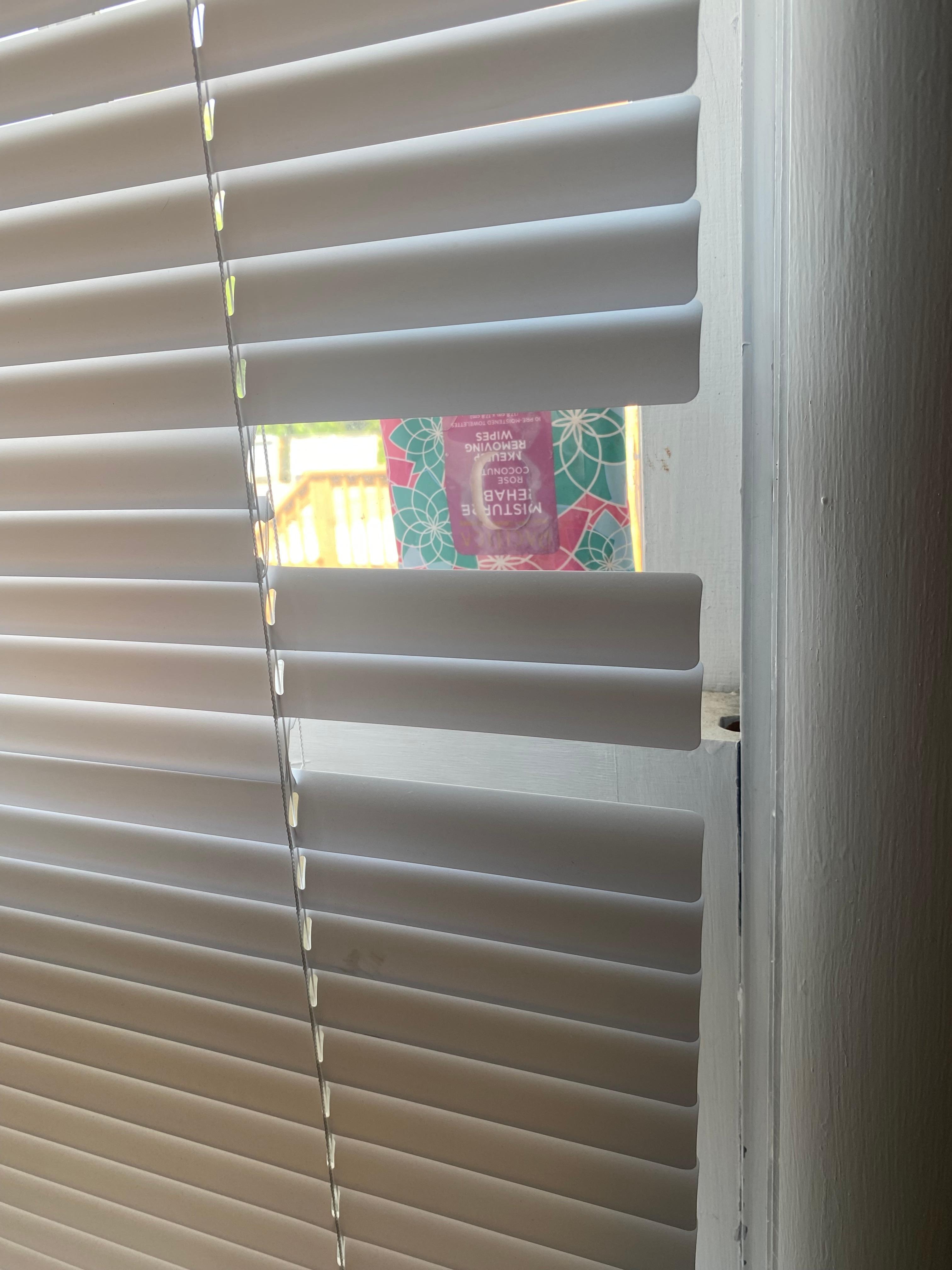 Bathroom blinds broken with a cardboard tissue box to fill the hole