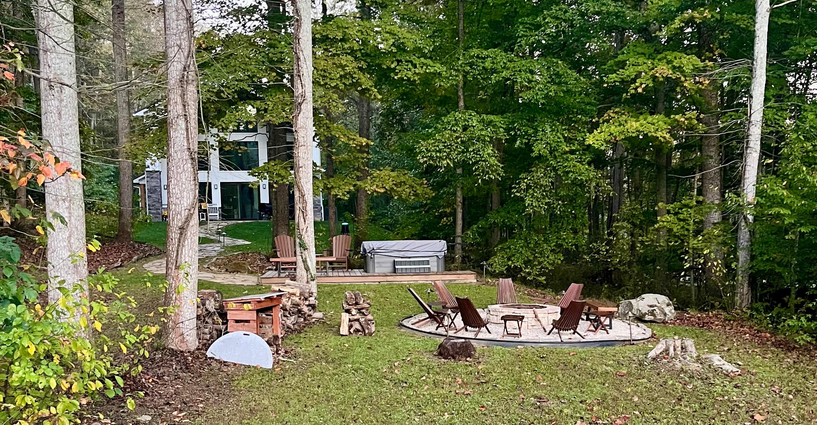 View of fire pit, hot tub & home