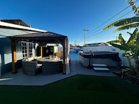 View of gazebo with seating. fire table and hot tub