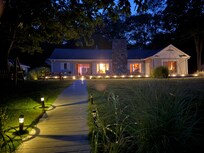View of the home from the lakefront deck at night.