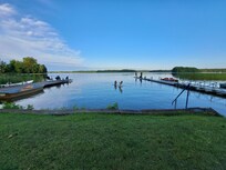 Blick vom Ufer auf den See mit Schwimmsteg und Anglersteg