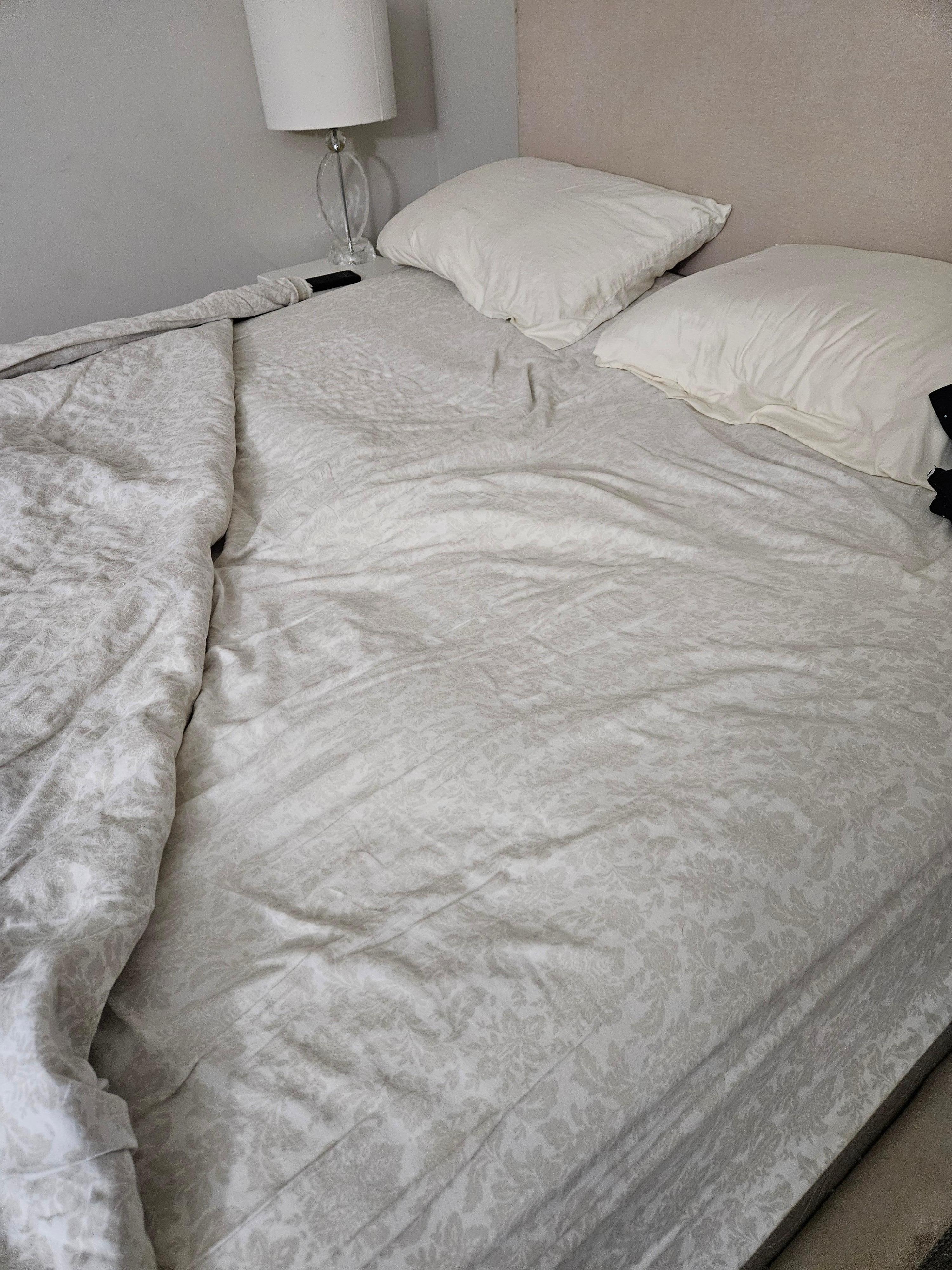 That lump in the middle of the bed is NOT part of the sheet but instead part of the mattress topper. It would not go away with any amount of smoothing.