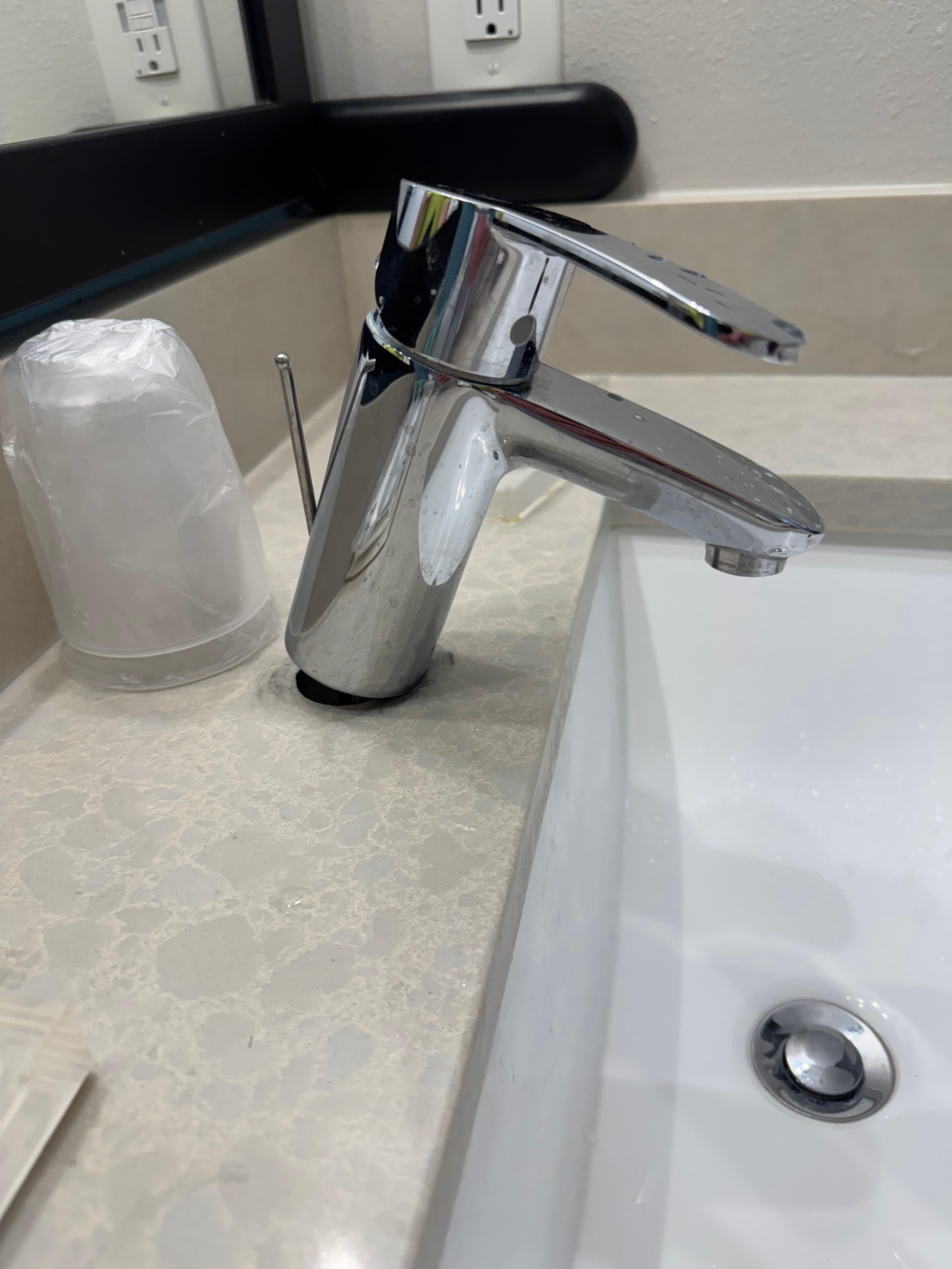 Sink faucet is just sitting on the vanity top.  It isn’t attached.