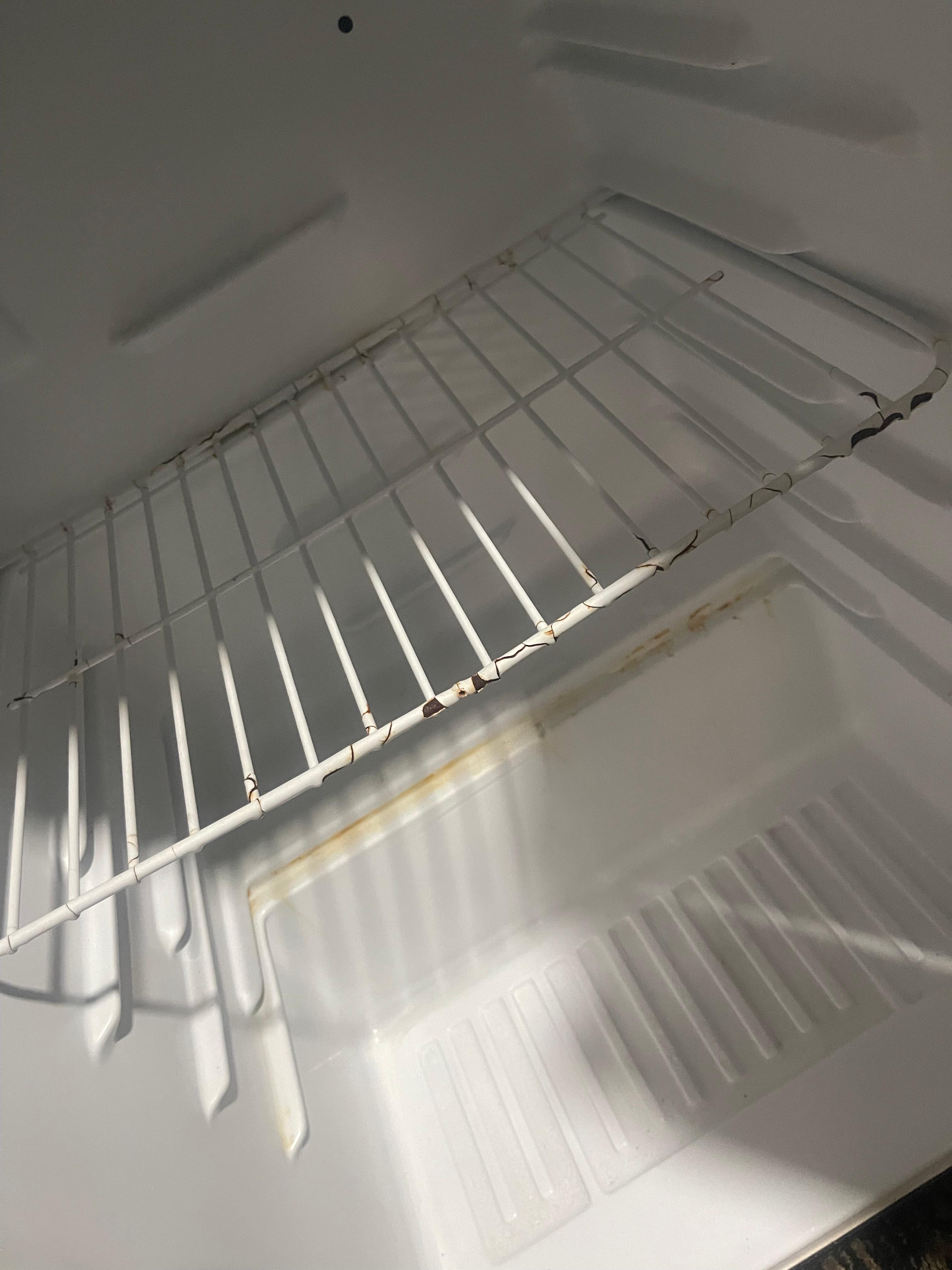 Rusted and dirty mini fridge 