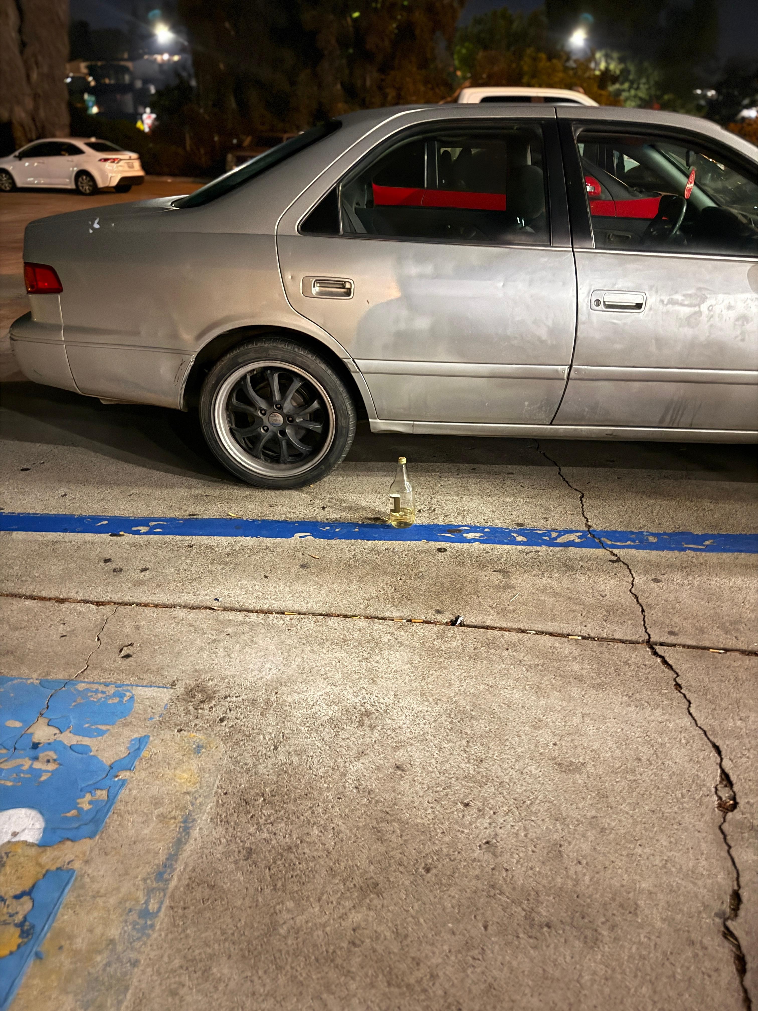 Beer bottles and broken down cars in front of the lobby