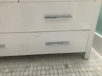 Finish on sink drawers appears to have been damaged by prior water leaks