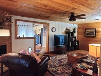 Living room with two recliners, sleeper sofa, cozy fireplace, and ROKU-equipped tv.
