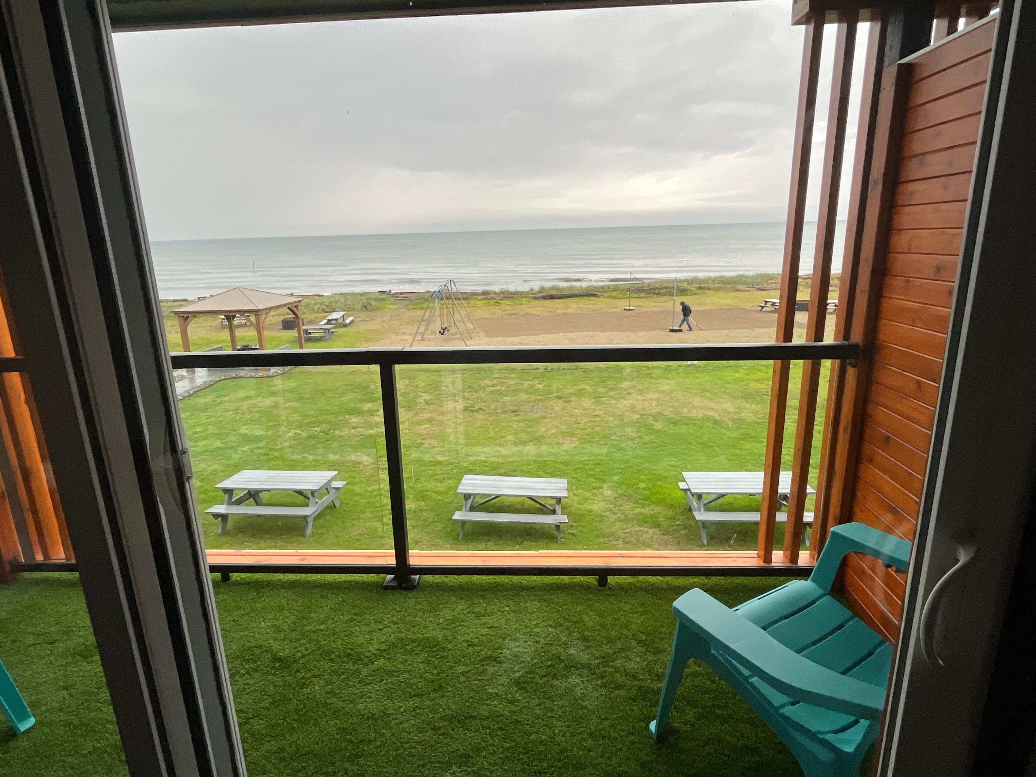 View through patio door looking to the beach and ocean