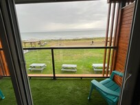 View through patio door looking to the beach and ocean