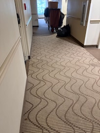 The dead roach in the hallway in relation to the cleaning cart