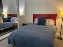 Two queen beds in one large room separated by a partition.