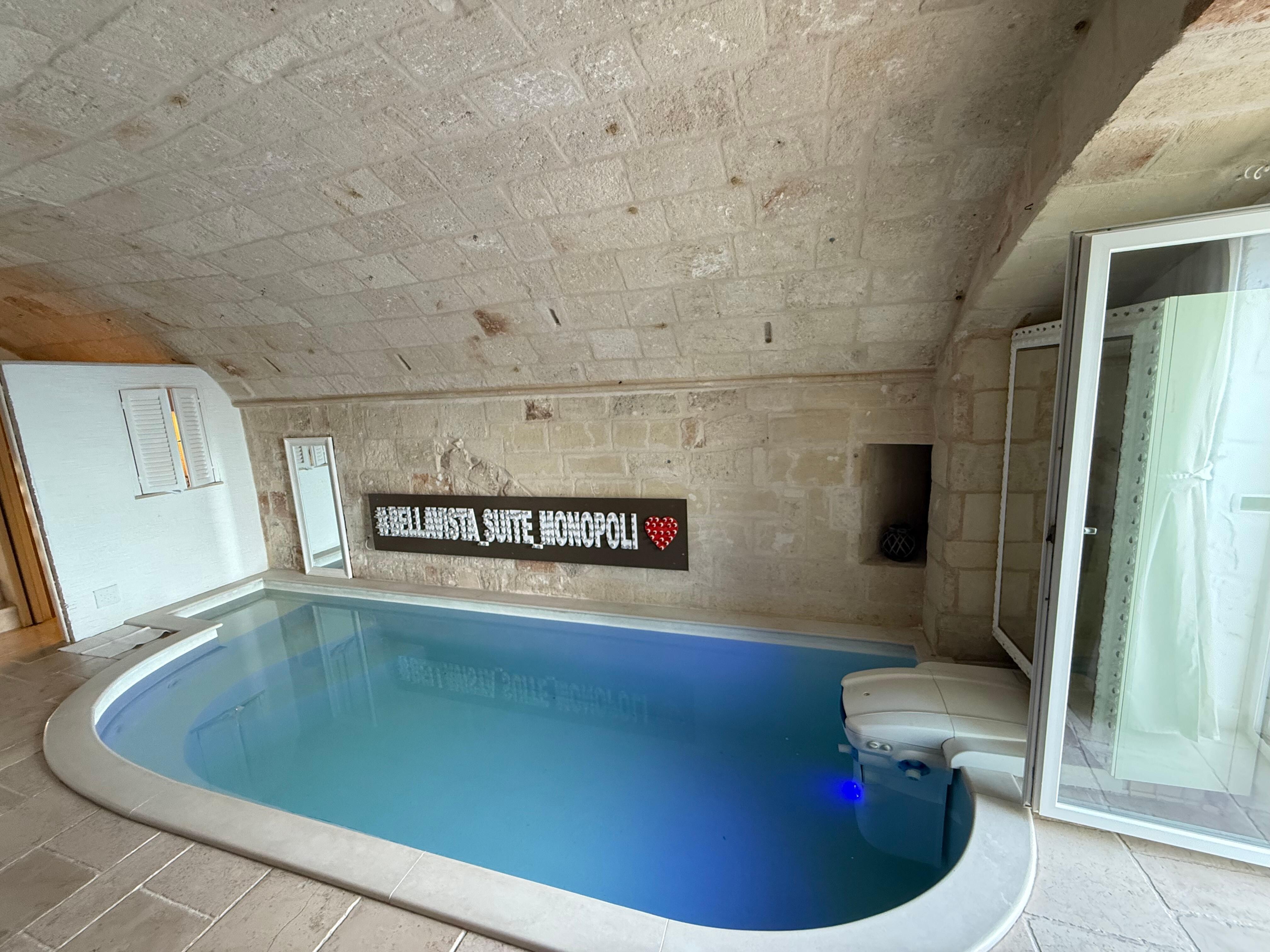 Indoor heated pool with different colorful lights and jets.