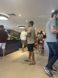 Pessoas tentando se servir no café.