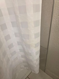 Visible urine on shower curtain and floor