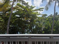 This is the "View" from the balcony. The greenish color through the trees are tennis courts-NOT the ocean