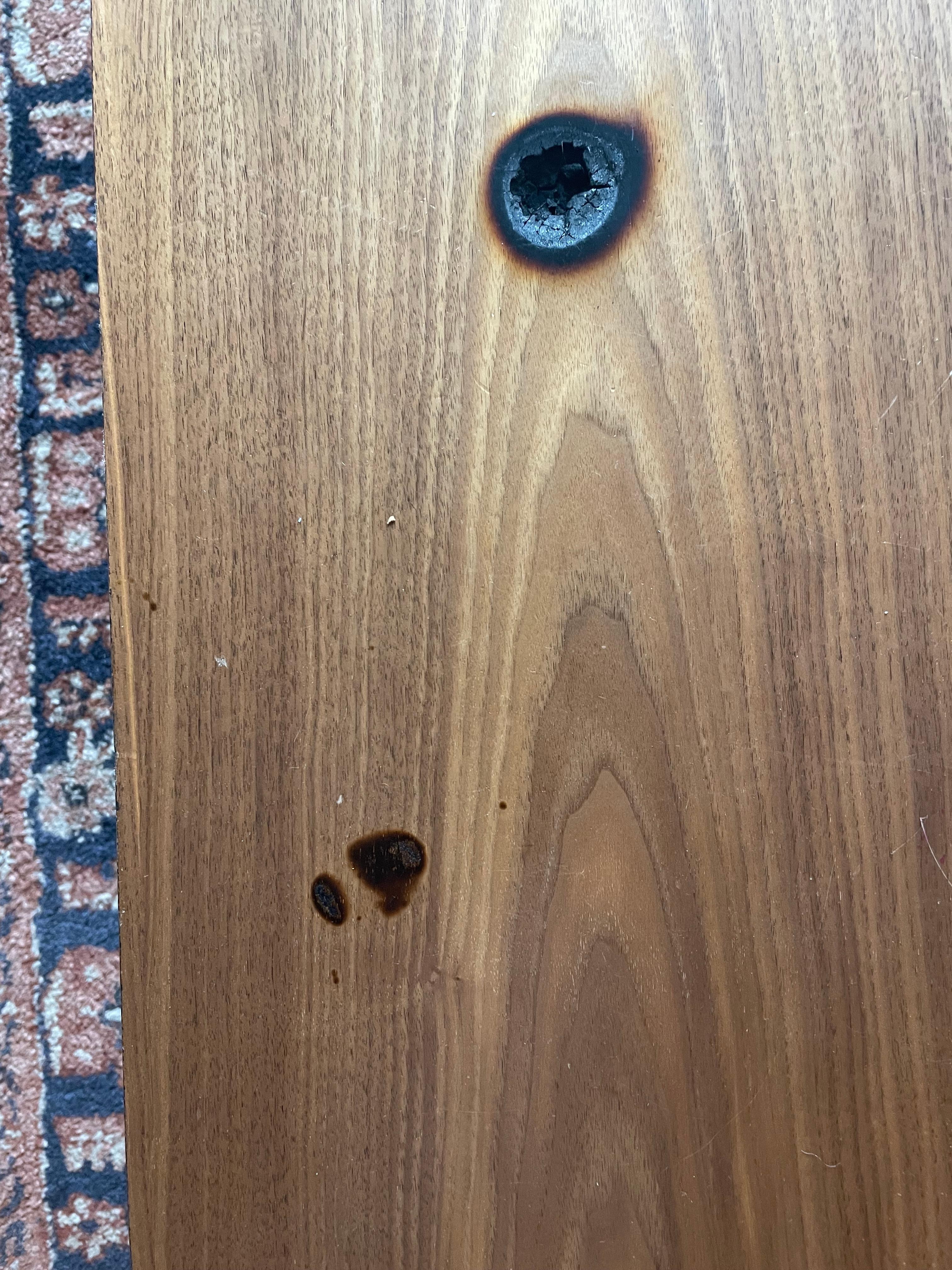 This is a table in room 303. It looks like something hot was dropped on the table. This was here when our friends arrived.