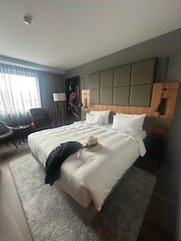 Schlafzimmer mit bequemen Bett und tollem großen Fernseher sowie Sitzgelegenheiten