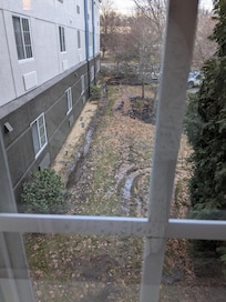 View from room of torn up yard, roofing shingles