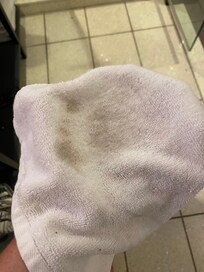 Wiping wet rag on the room floor.