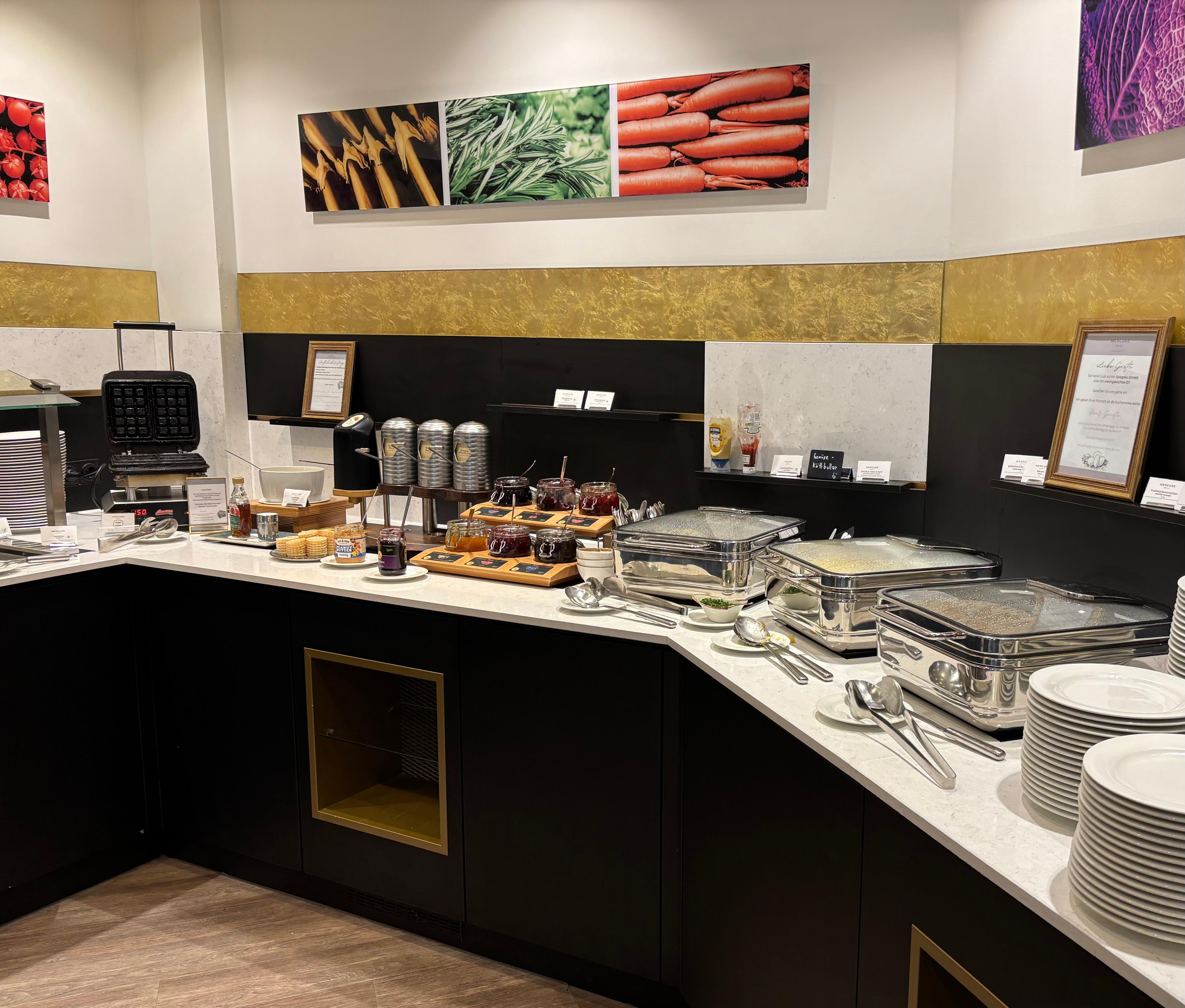 Breakfast - waffle maker and batter on the left, hot food on the right. 