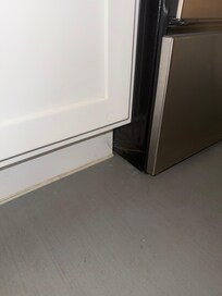 Cobwebs under kitchen cabinet next to stove.