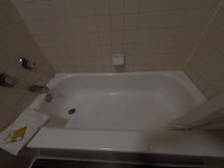 Tub with stains and a small hole in the center of it.