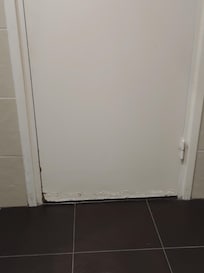 The bottom of the bathroom door has water damage.